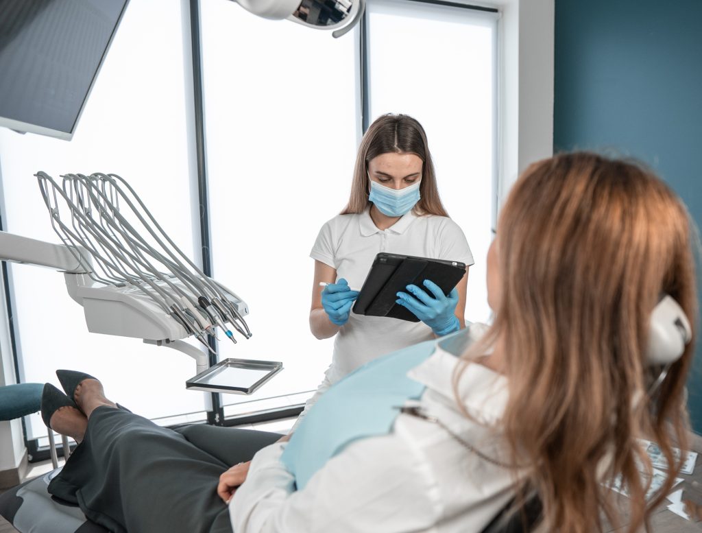 Dental hygienist consulting with a patient during a checkup in Wilmington, MA